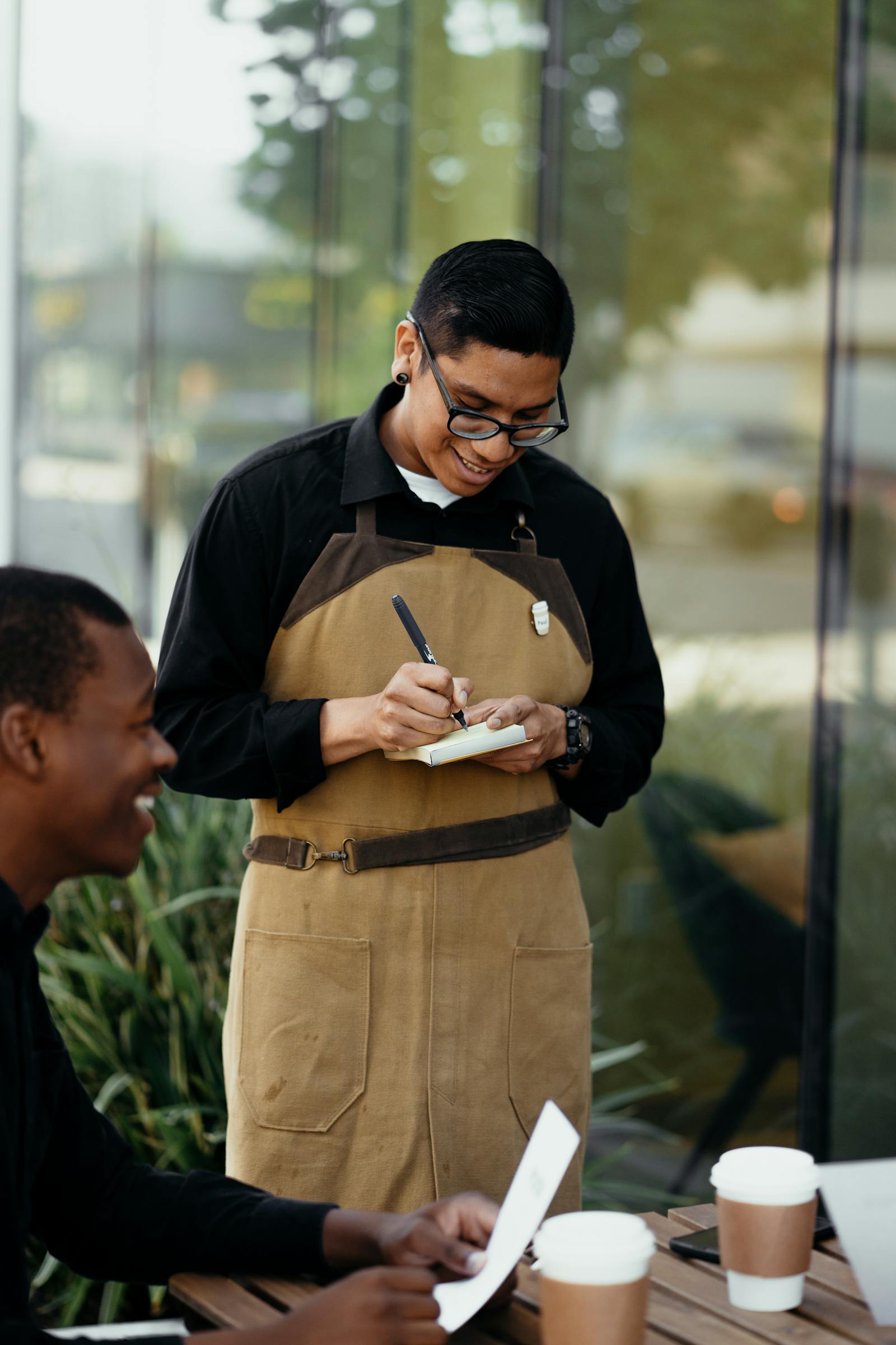 A waiter taking a guest's order at an outdoor cafe